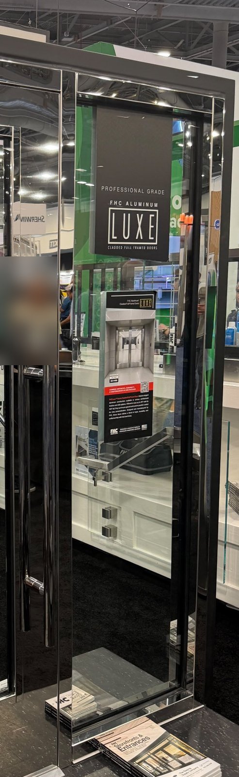 Storefront entrance door sample with mirror-polished stainless steel cladding on the full aluminium frame and a matching polished pull