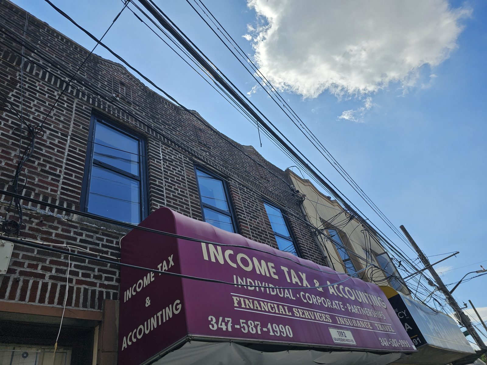 Brick mixed-use building at 1192 Gravesend Neck Road, Brooklyn, after Cortizo tilt-and-turn window replacement