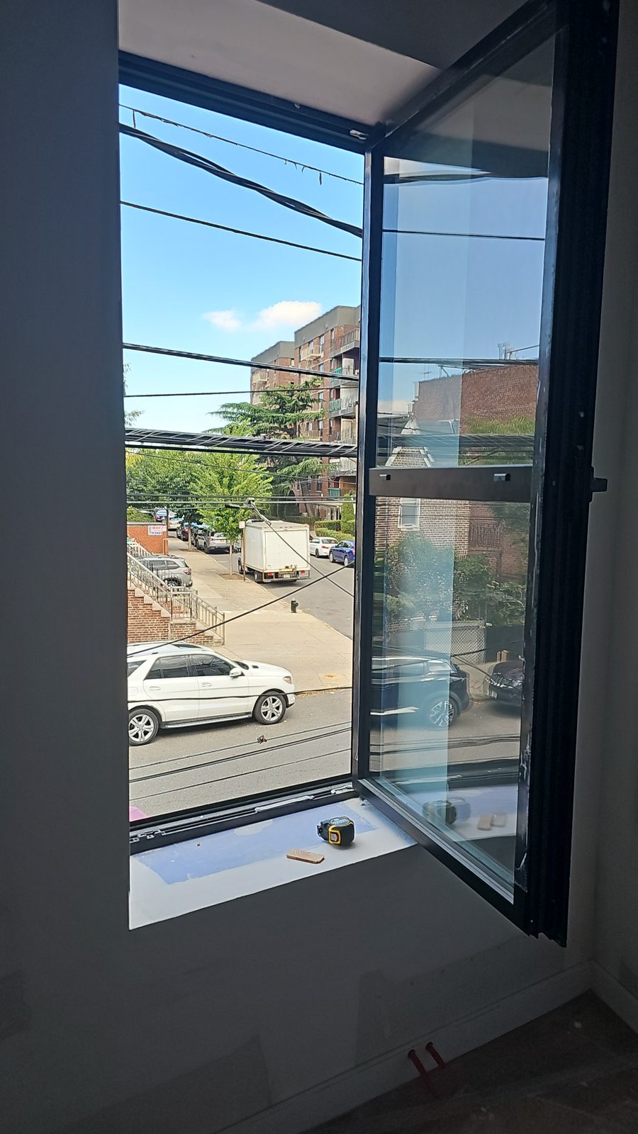 Cortizo tilt-and-turn sash open inward showing the street, window replacement Brooklyn
