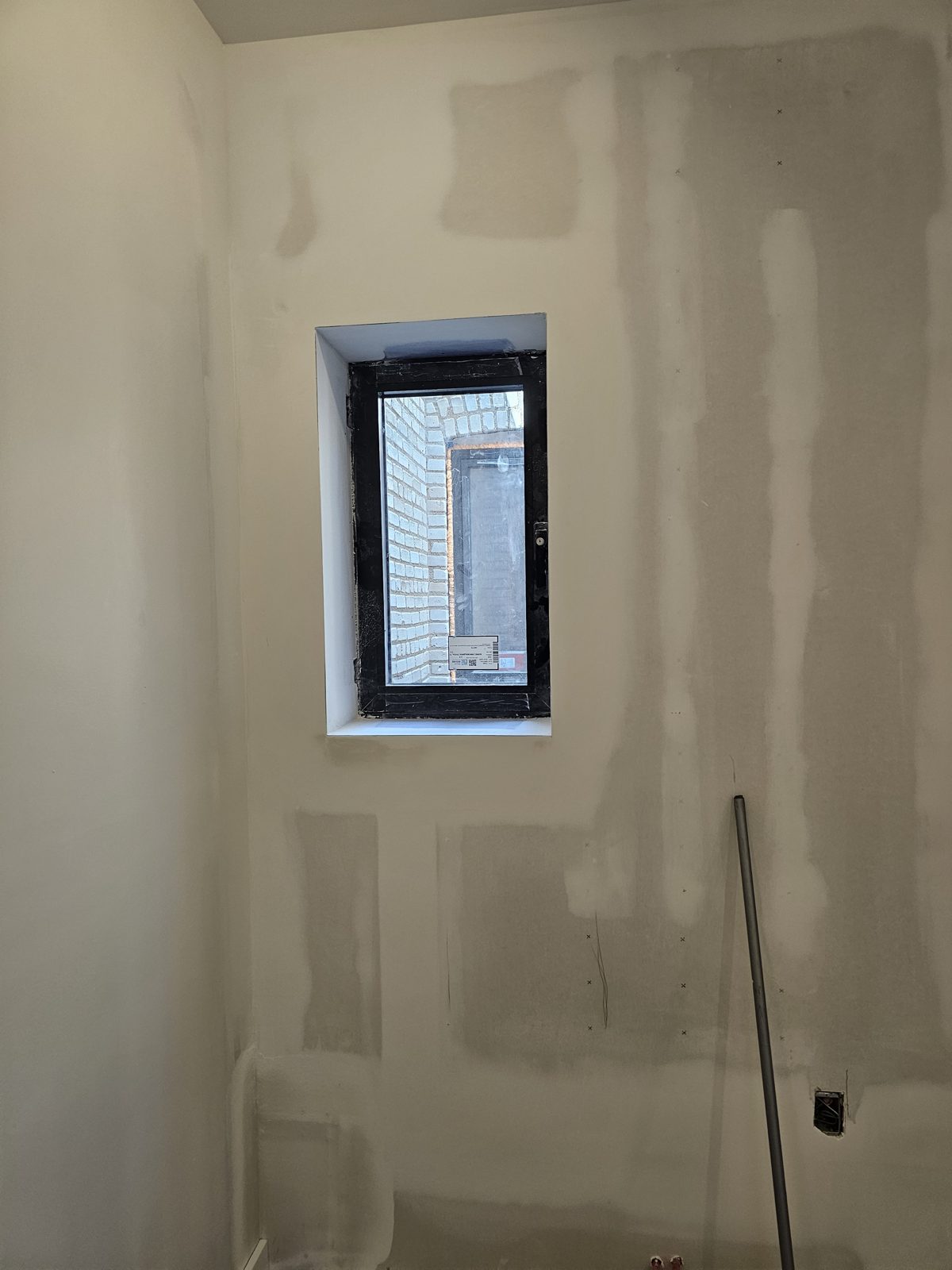 Small bathroom tilt-and-turn window in black Cortizo aluminum