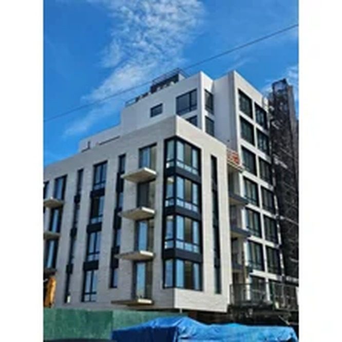 New multi-story building at 130 Beach 120th Street, Rockaway Park, Queens, with custom dark aluminum windows and balcony doors