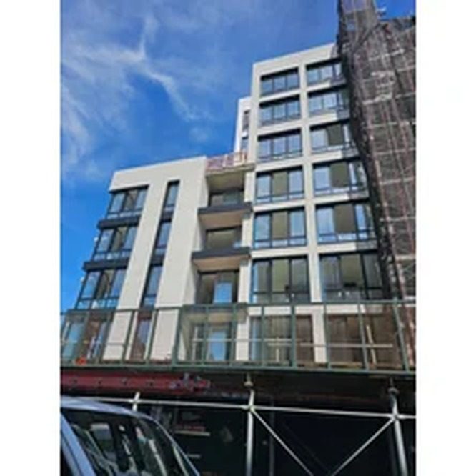 Facade of 130 Beach 120th Street, Rockaway Park, showing custom aluminum windows and doors opening to balconies
