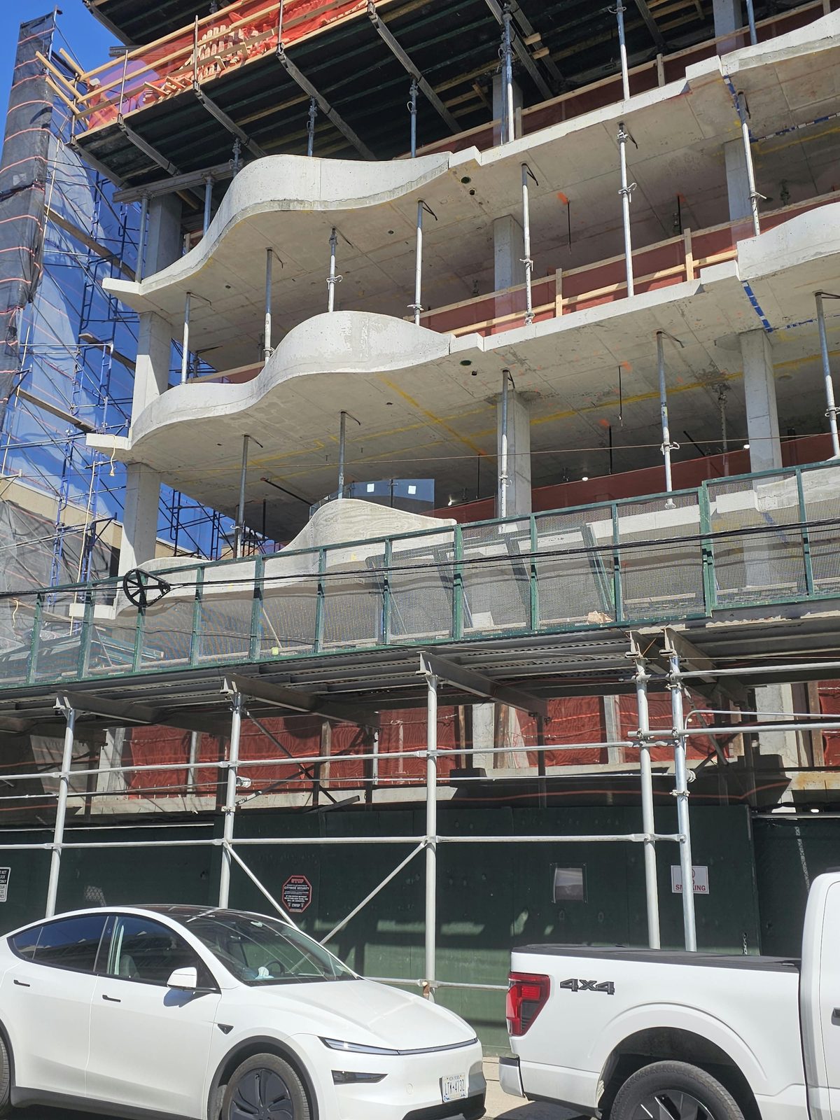 The new building at 1505 Emmons Avenue under construction, wave-form concrete balcony slabs on every floor