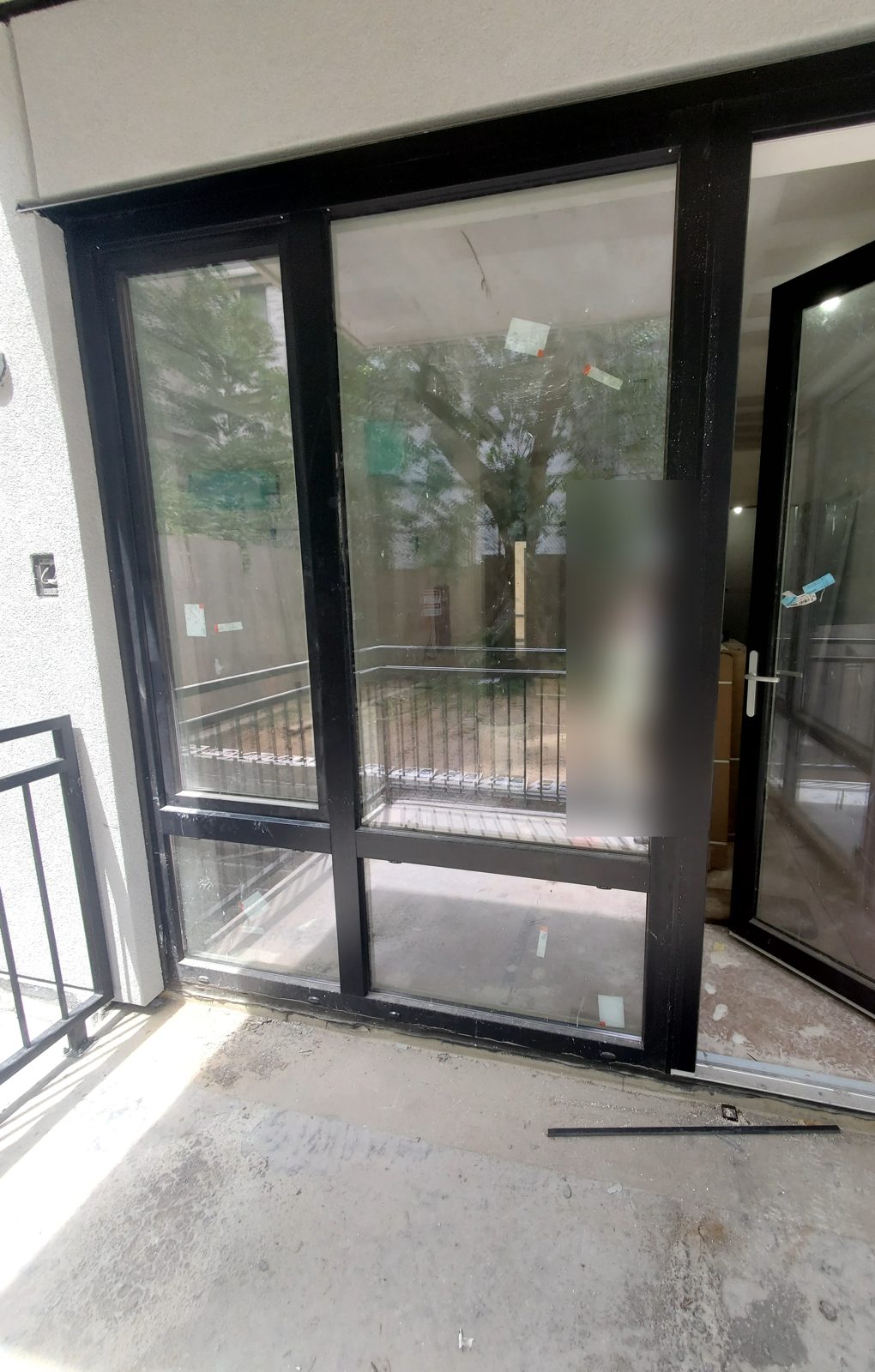Black-framed terrace door open beside full-height fixed glass at 1526 Sedgwick Avenue, Bronx