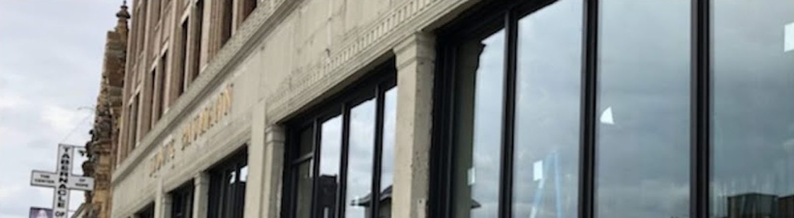 Tall lites of glass between slender aluminum tube members in the storefront at 165-19 Jamaica Avenue, Jamaica, Queens