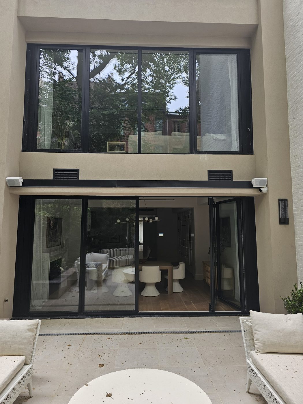 Cortizo aluminum bifold door open from the garden into the dining room at 165 East 64th Street