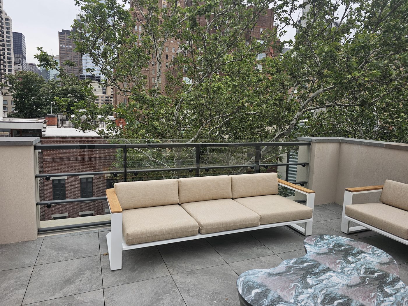 Terrace at 165 East 64th Street with custom glass railing guard on black horizontal rails and standoff fittings