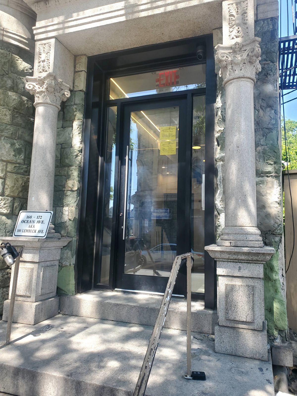 New black aluminum and glass entrance with sidelights and transom between stone columns at 168-172 Ocean Avenue, Jersey City NJ