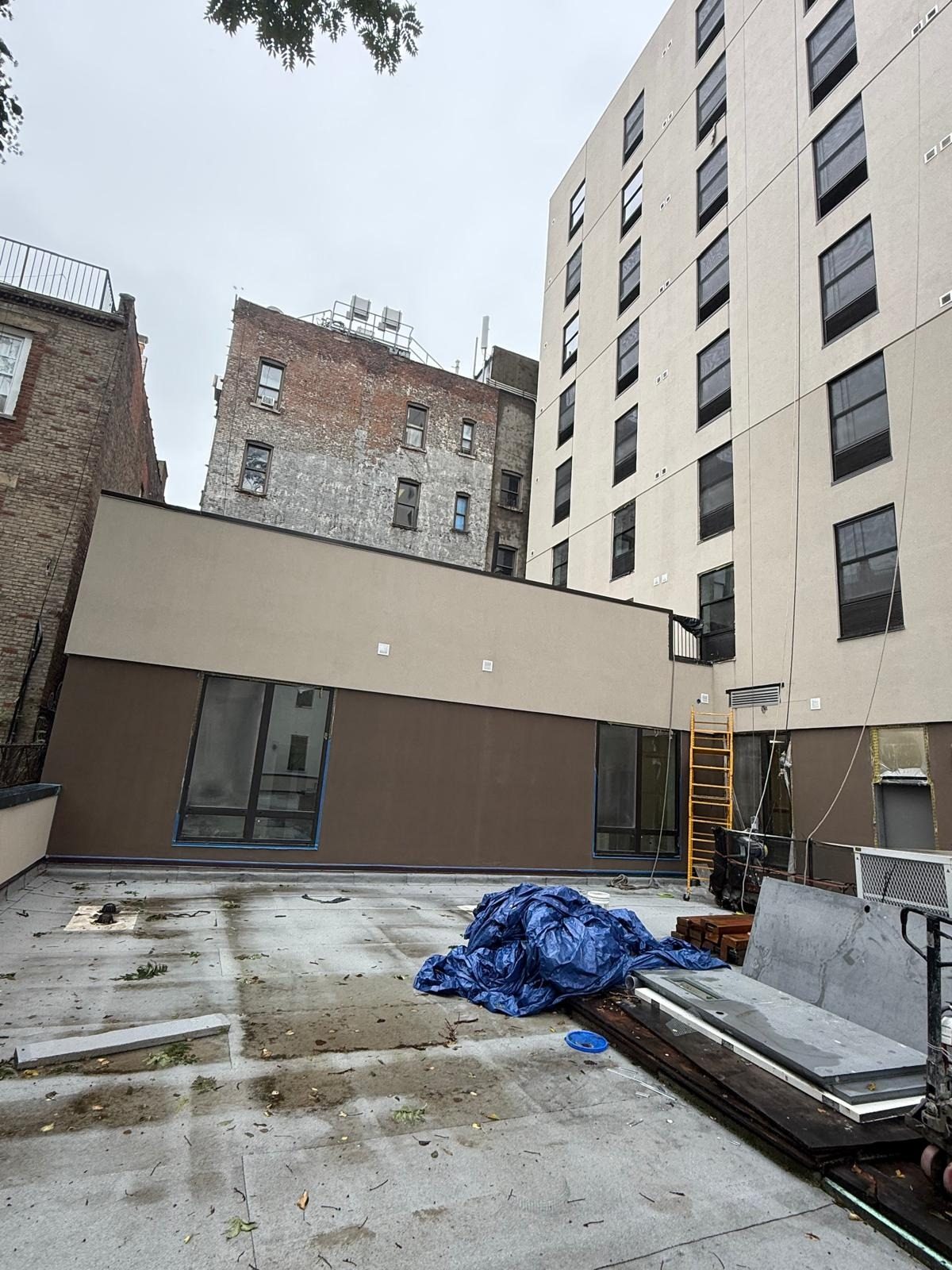 Courtyard view of 1763 Amsterdam Avenue, Manhattan, showing windows on the tower and large openings in the low wing