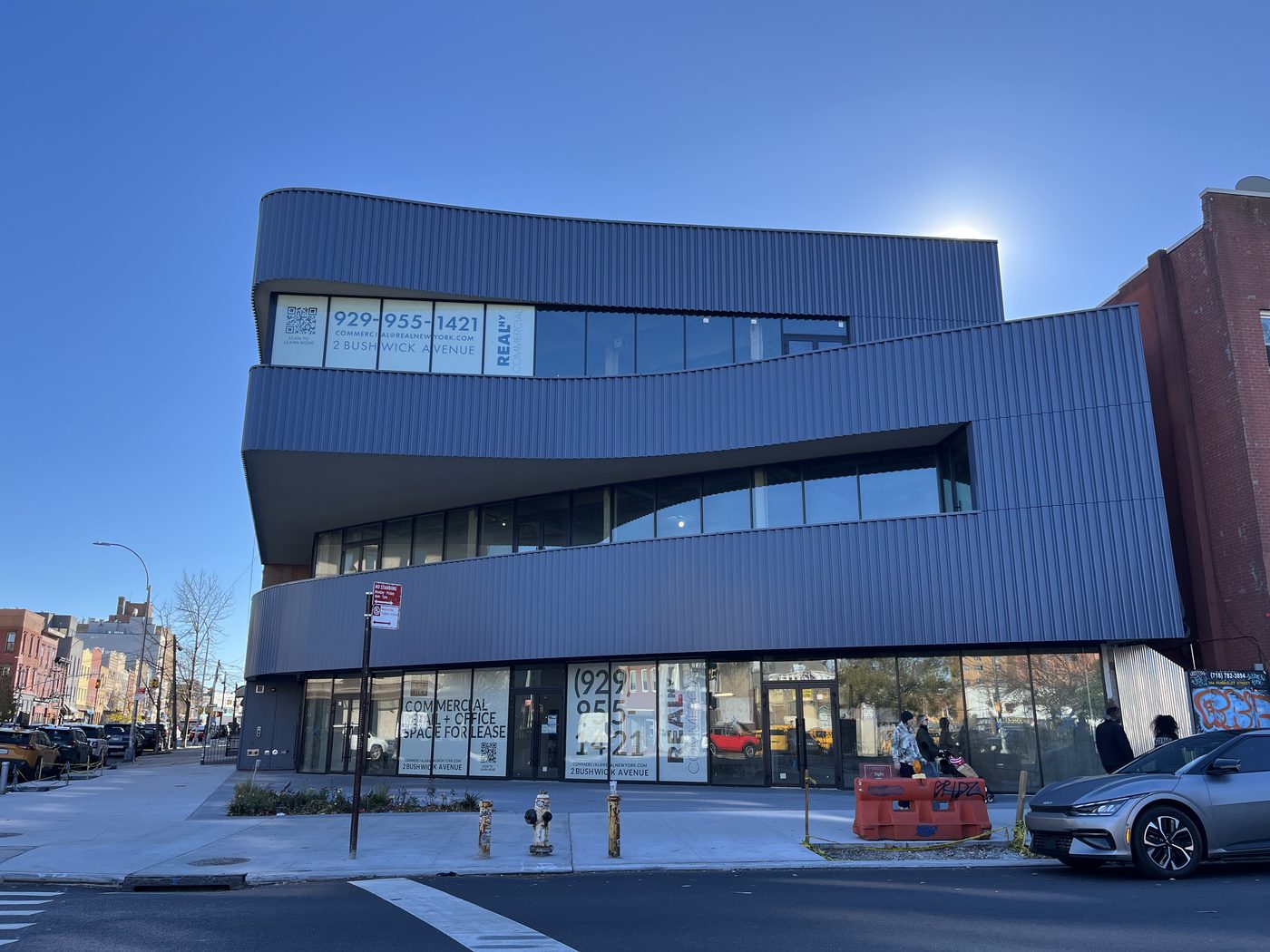 2 Bushwick Avenue, Williamsburg: three floors of continuous curved ribbon glazing in grey Alutech framing between bands of dark corrugated cladding