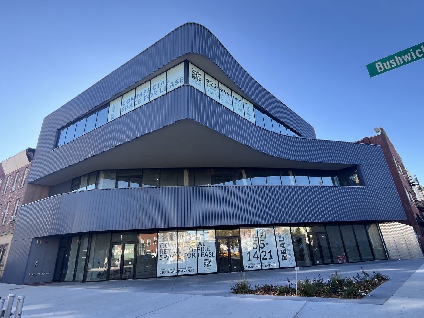Cantilevered corner of 2 Bushwick Avenue with continuous glazing wrapping the curve on all three floors