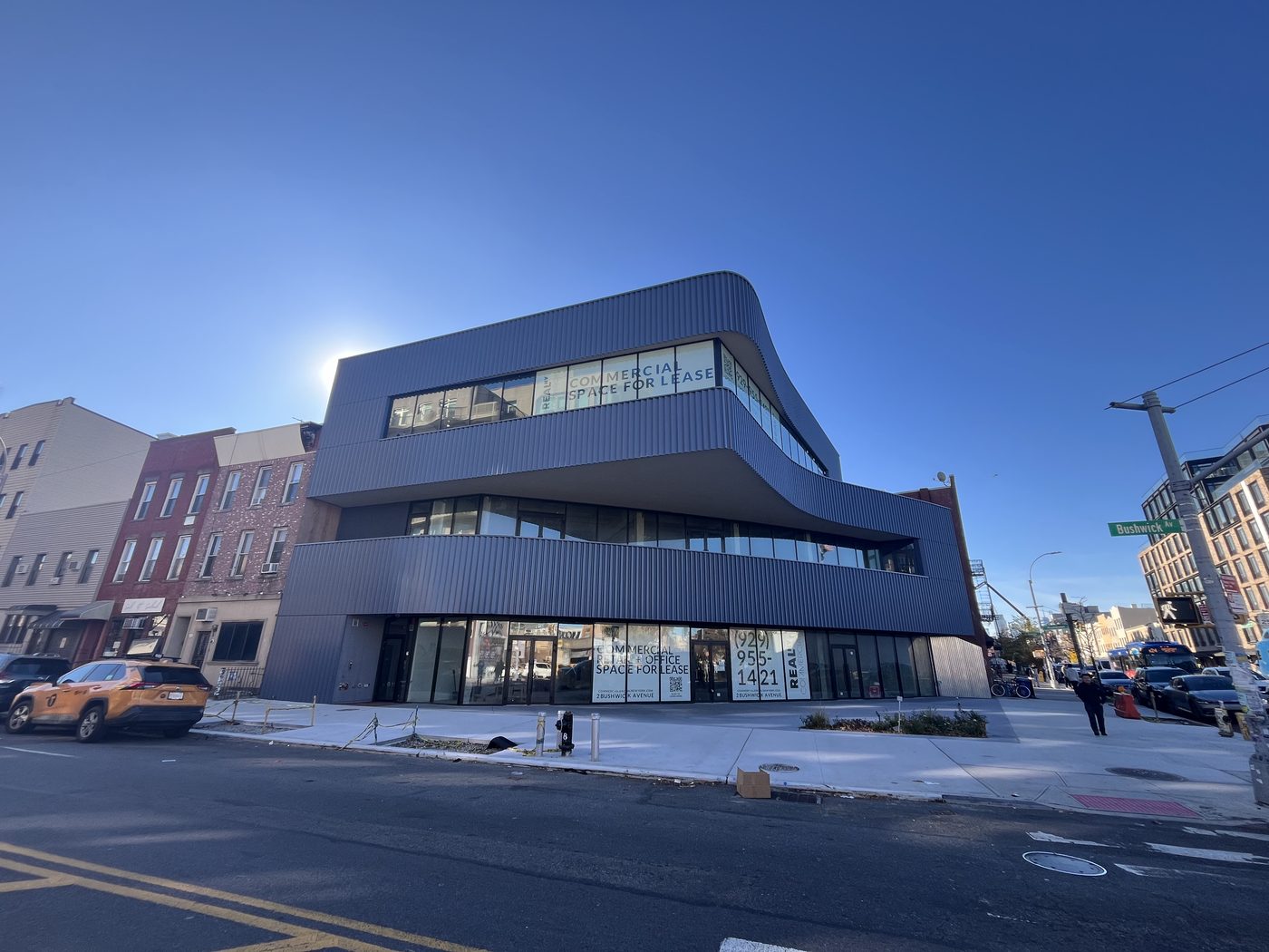 Metropolitan Avenue elevation of 2 Bushwick Avenue with sweeping ribbon windows and ground-floor storefront