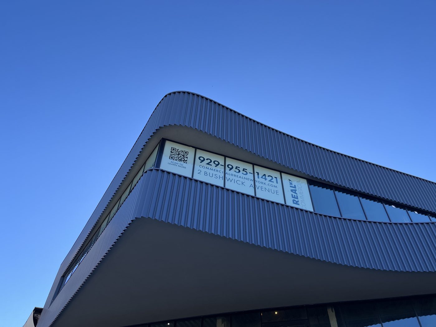 Close view of faceted ribbon glazing following the curve of the corrugated facade at 2 Bushwick Avenue