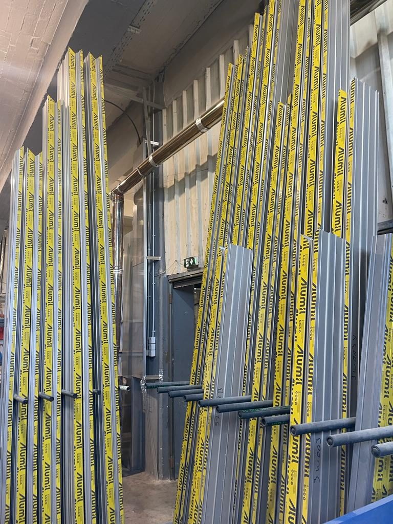 Racks of full-length Alumil aluminum profiles in protective tape