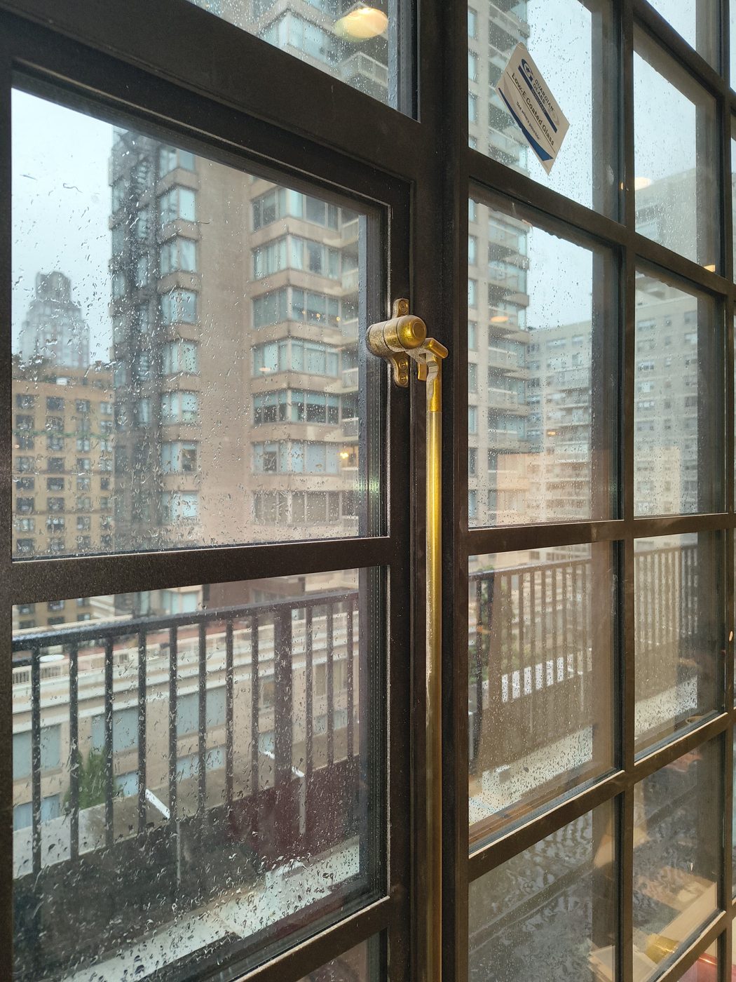Close-up of the custom brass cremone bolt on a steel casement window at 205 East 69th Street