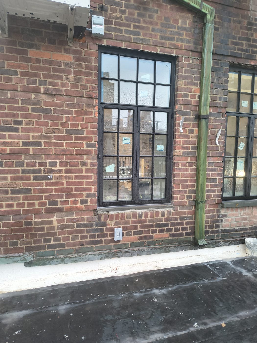Two new steel windows in the brick facade seen from the penthouse terrace at 205 East 69th Street