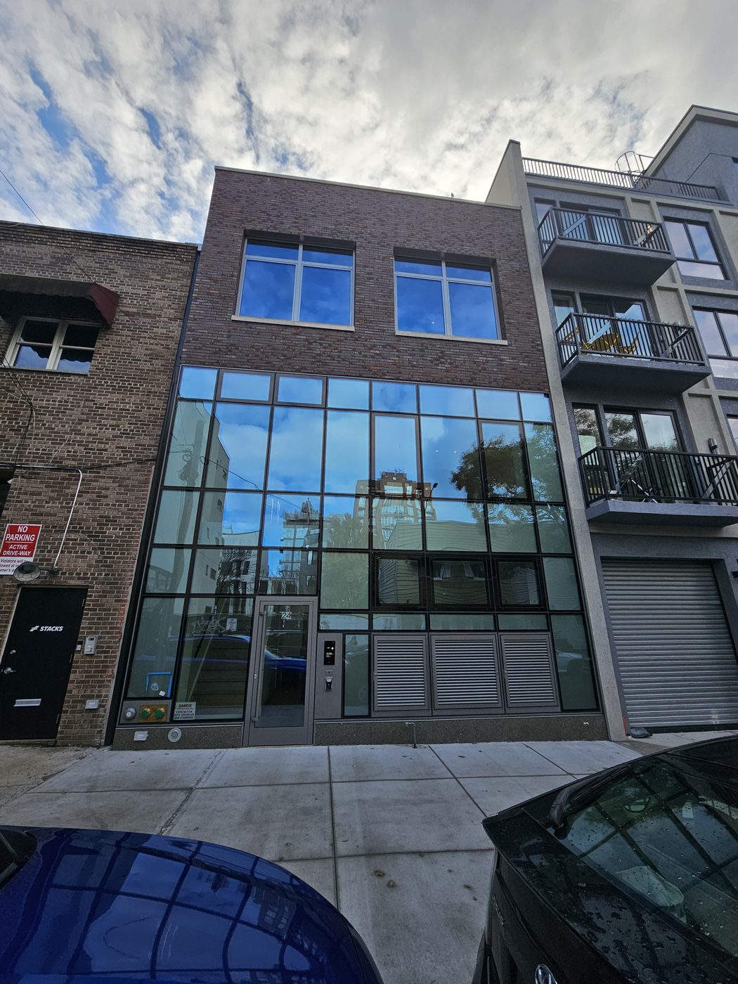Front of 24 Frost Street, Williamsburg: structurally glazed two-storey curtain wall below brick with Everest aluminum windows
