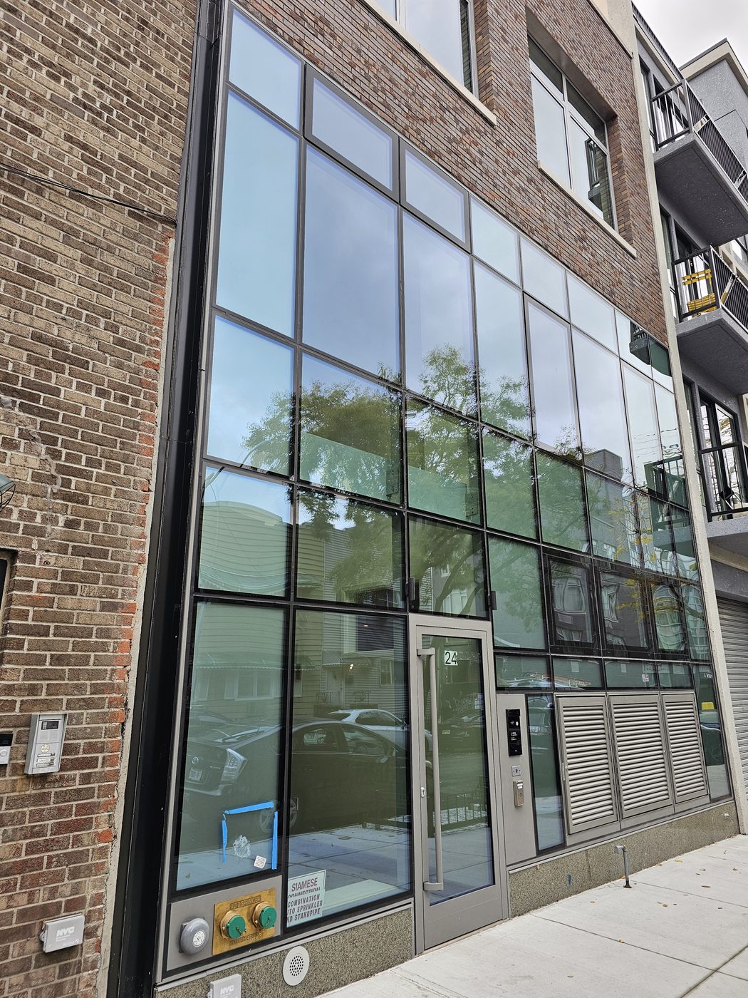 Close view of the structurally glazed curtain wall and Everest aluminum entrance door at 24 Frost Street, Williamsburg