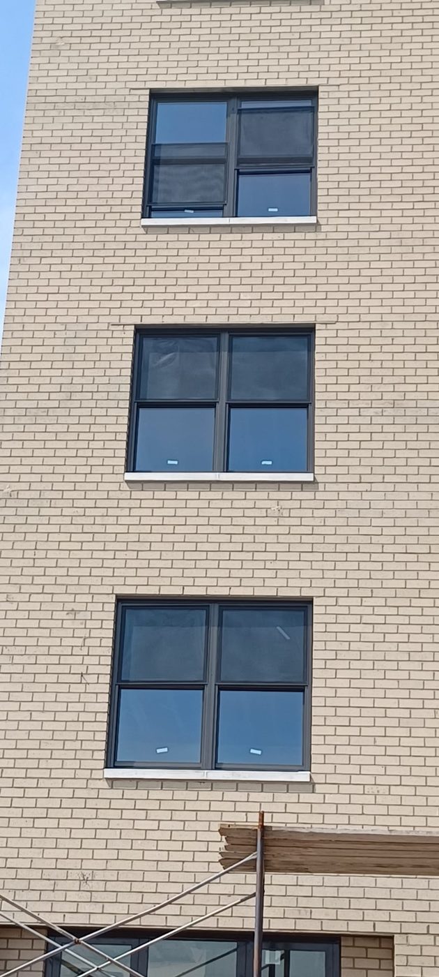 Front facade of Surfview Towers, 25 Franklin Boulevard, Long Beach, with new custom aluminum double-hung windows in the brick