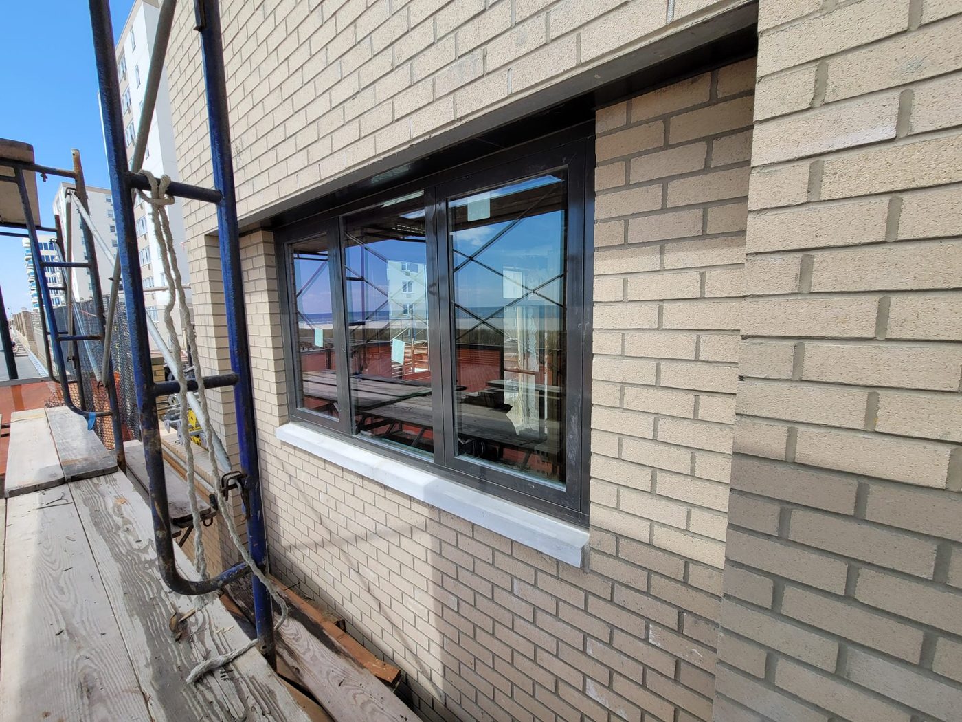 New dark aluminum windows in the brick at 25 Franklin Boulevard seen from the boardwalk-side scaffold
