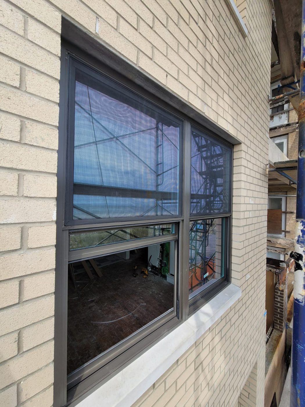 Close view of a new aluminum double-hung window with screens and the lower sash open at 25 Franklin Boulevard