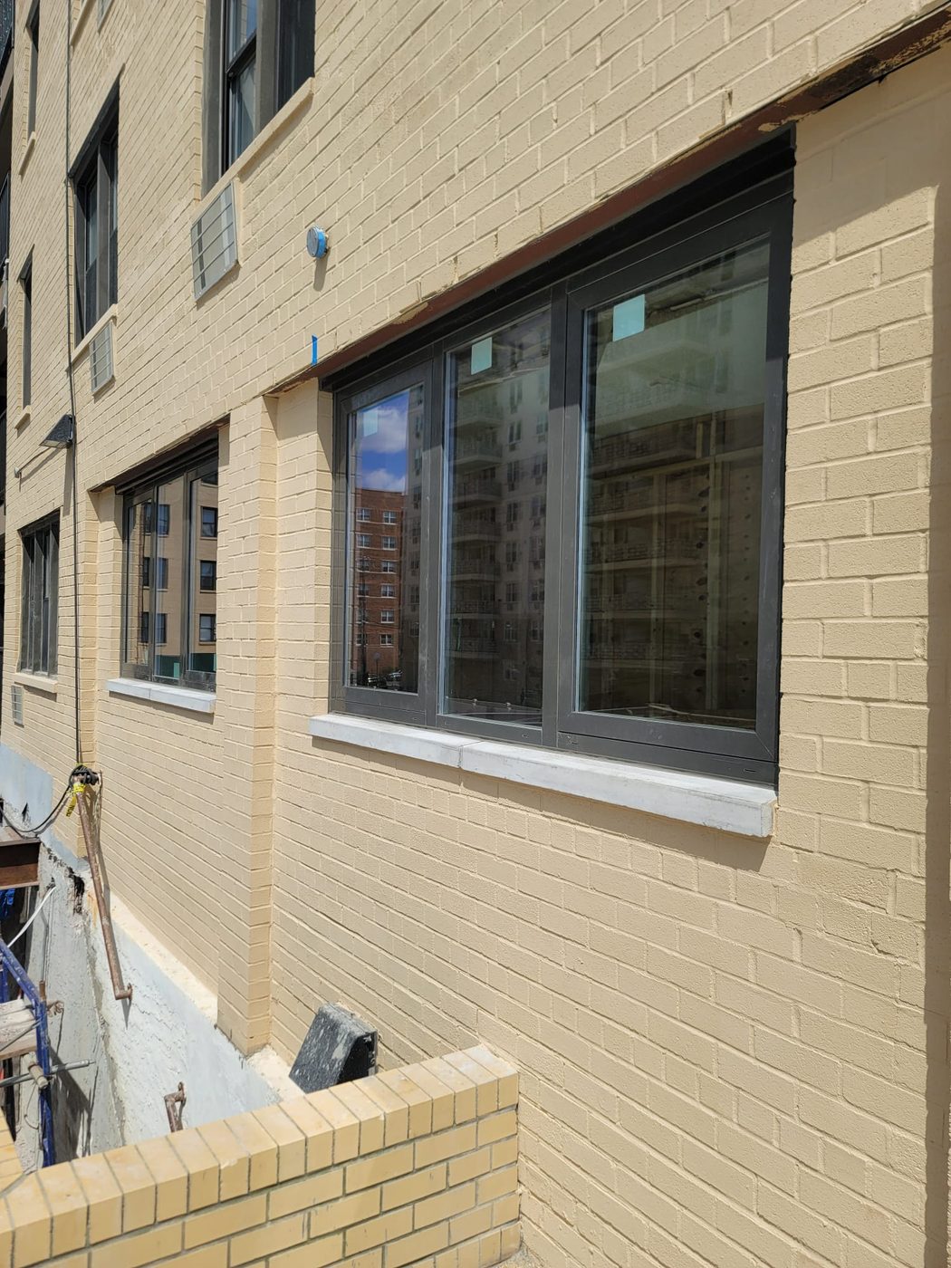 New triple aluminum window with black frames in painted brick at 25 Franklin Boulevard