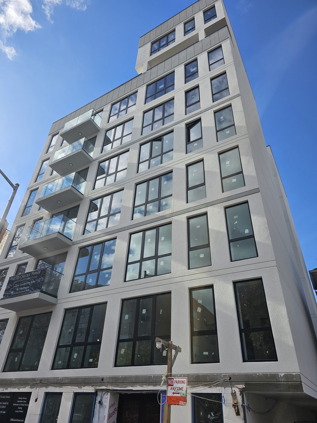 Ocean Avenue elevation of the condominium tower showing the aluminum window rhythm and setback upper floors