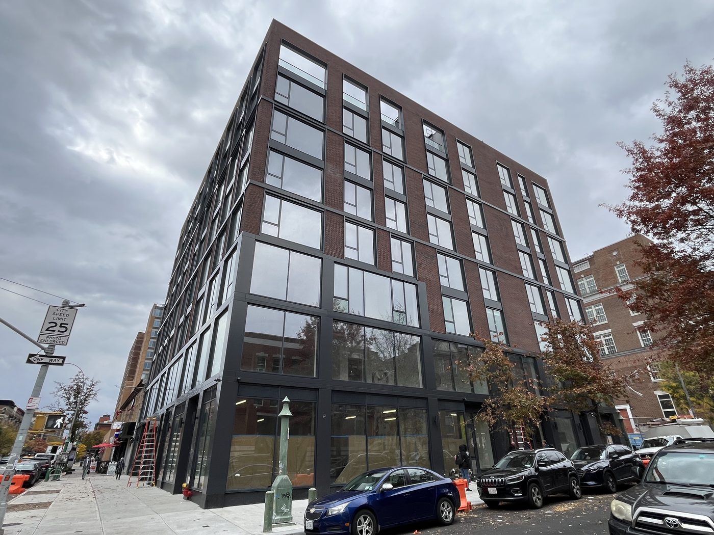 Corner elevation of 2535 Frederick Douglass Boulevard, Harlem, with Everest aluminum windows in dark brick above a two-storey curtain wall base