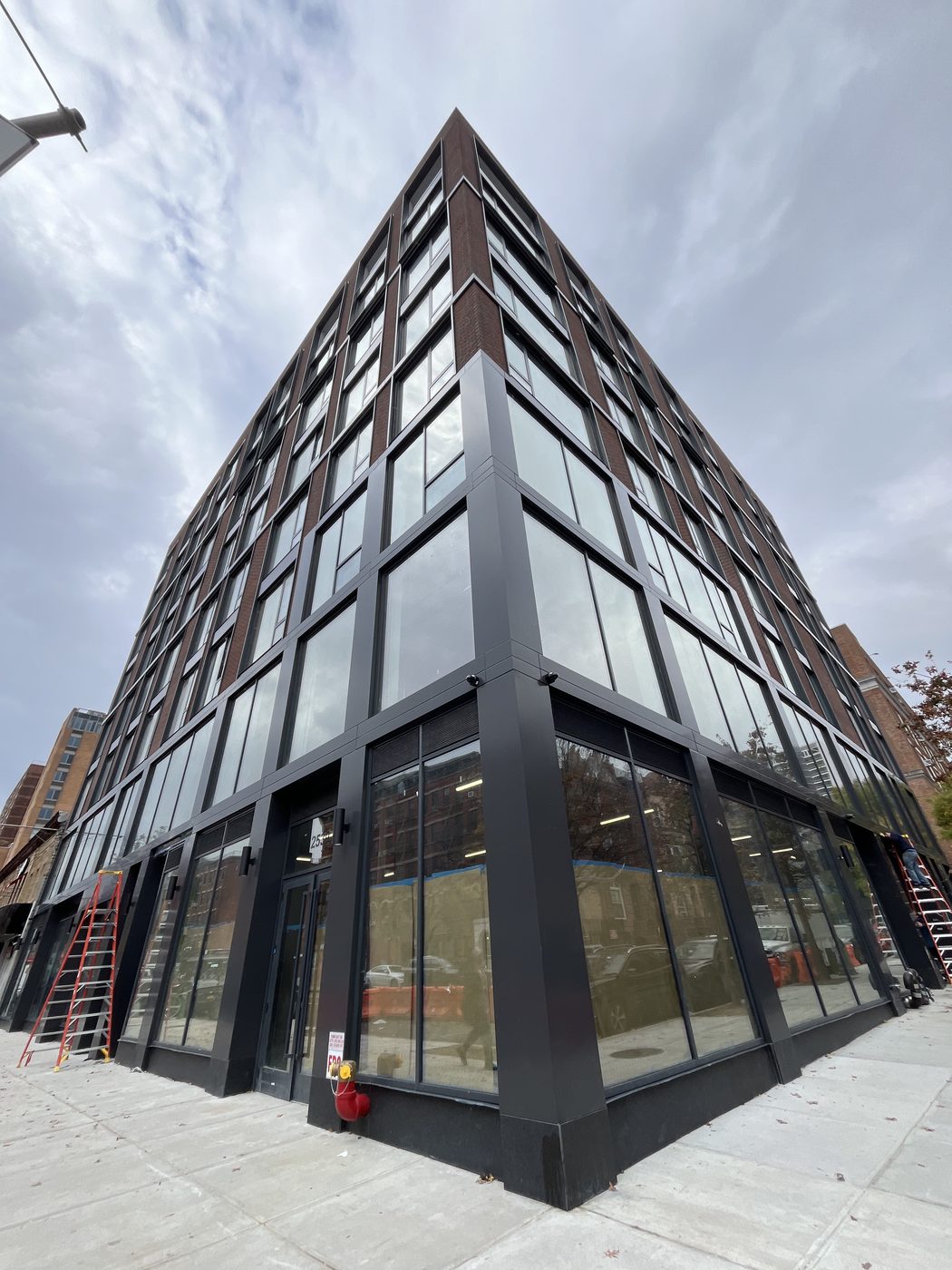 Corner of 2535 Frederick Douglass Boulevard, Harlem, with two-storey Everest curtain wall, aluminum composite panel corner and dark aluminum windows above
