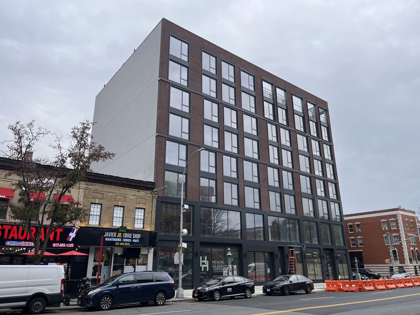 Full Frederick Douglass Boulevard elevation of 2535 Frederick Douglass Boulevard, Harlem, with aluminum windows, curtain wall base and glass railings at the roof deck cutout