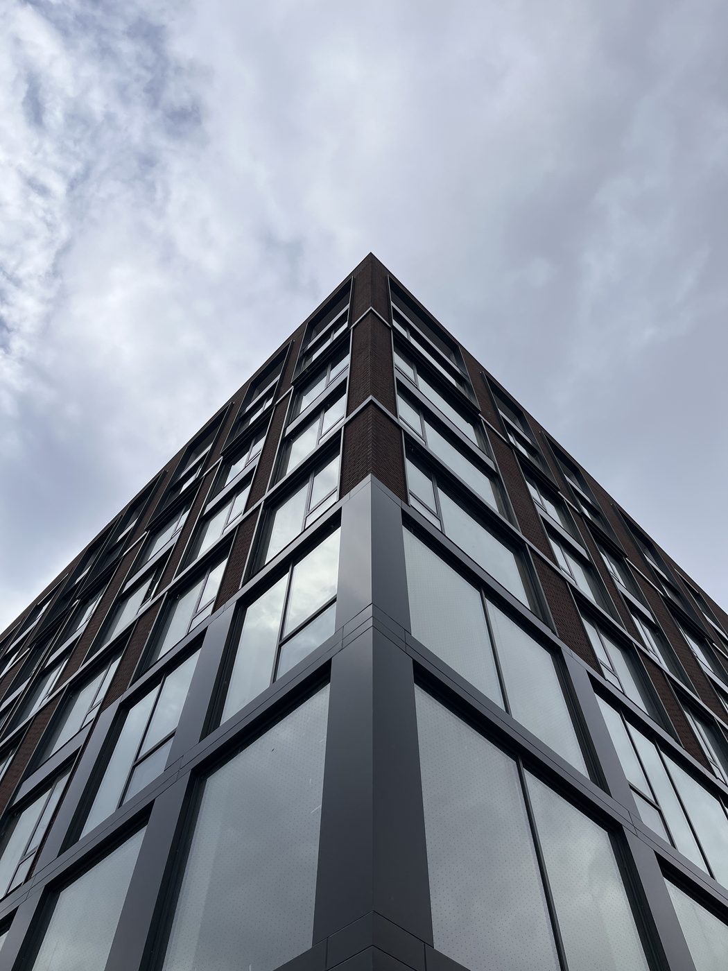 Looking up the corner of 2535 Frederick Douglass Boulevard, Harlem: dot-fritted curtain wall glass, aluminum composite panels and capping