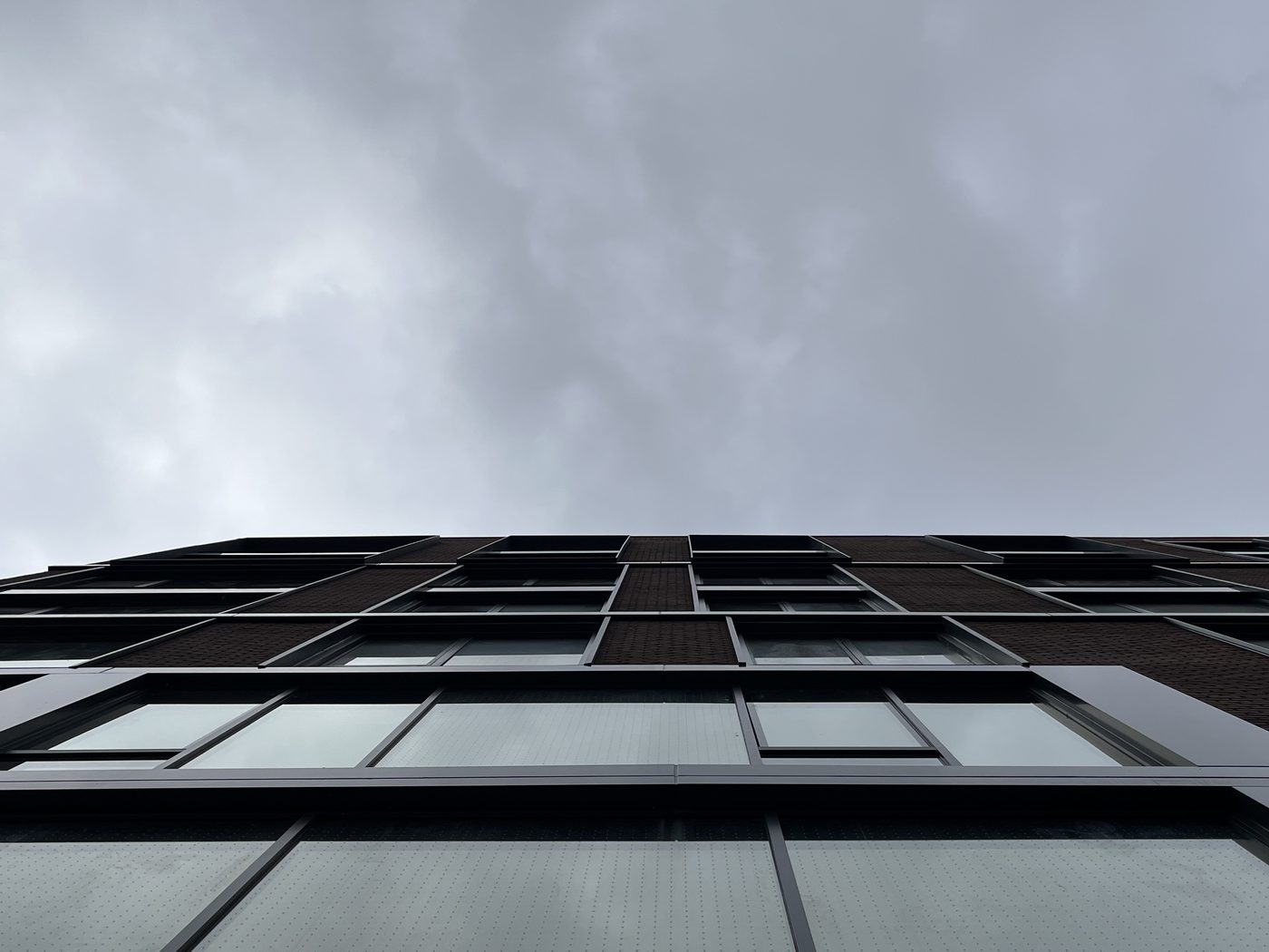 Looking straight up the facade of 2535 Frederick Douglass Boulevard, Harlem, at the aluminum window reveals and capping