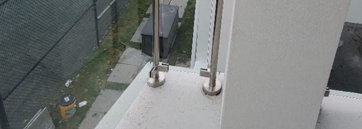 Stainless steel railing posts on round base flanges fixed to the balcony slab at 27 Runyan Avenue, Deal, NJ
