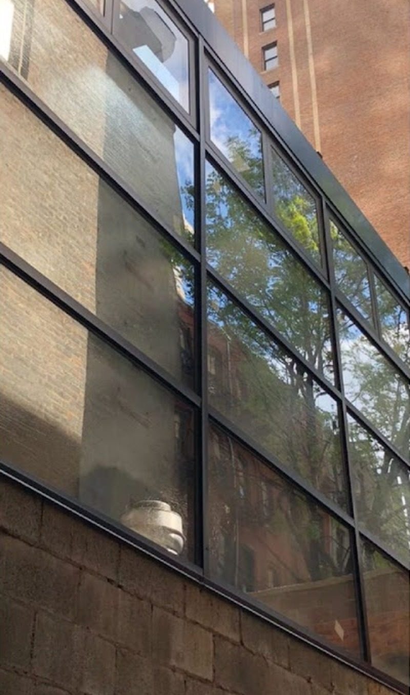 Exterior of the black aluminum curtain wall above a masonry base at the Civilian Hotel sunroom, 305 West 48th Street, Manhattan