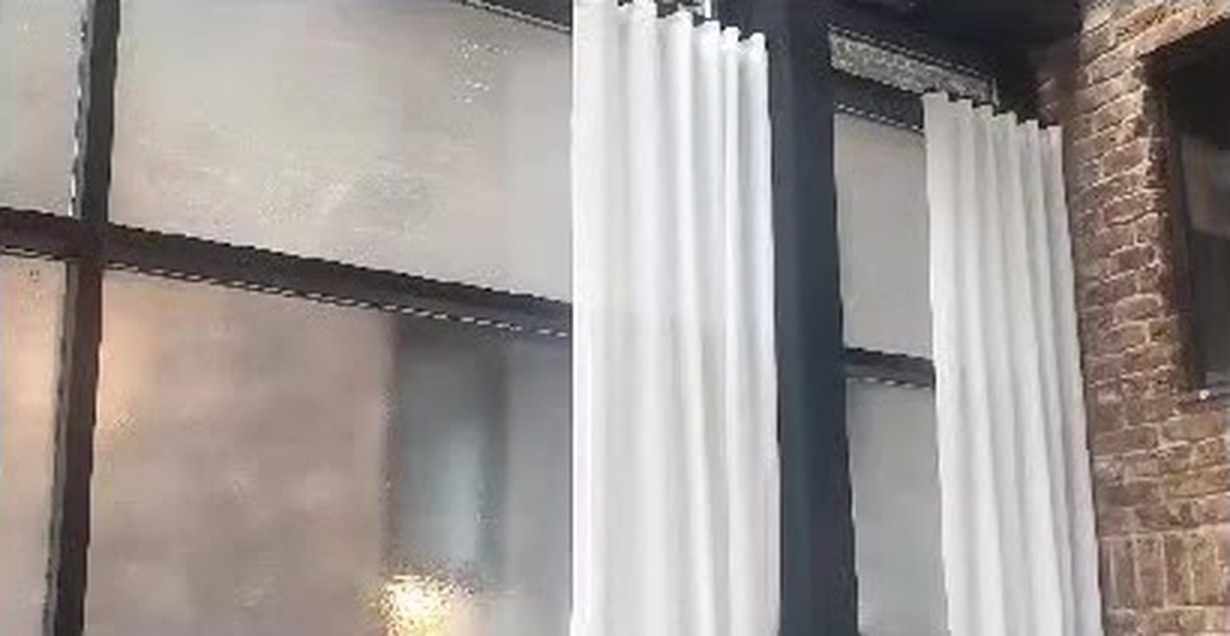 Interior view of the black-framed glass wall with white curtains in the sunroom at the Civilian Hotel, 305 West 48th Street