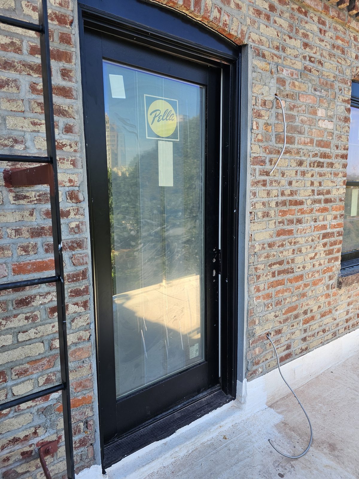 Full-glass Pella terrace door with black frame opening onto a roof terrace at 343 Hoyt Street, Brooklyn