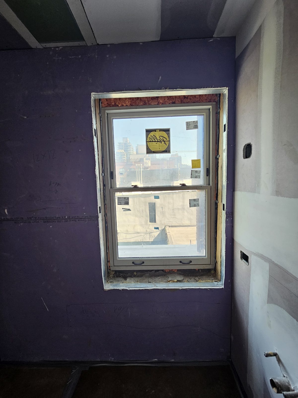 Interior view of a Pella double-hung window at 343 Hoyt Street before interior trim, insulation visible around the frame