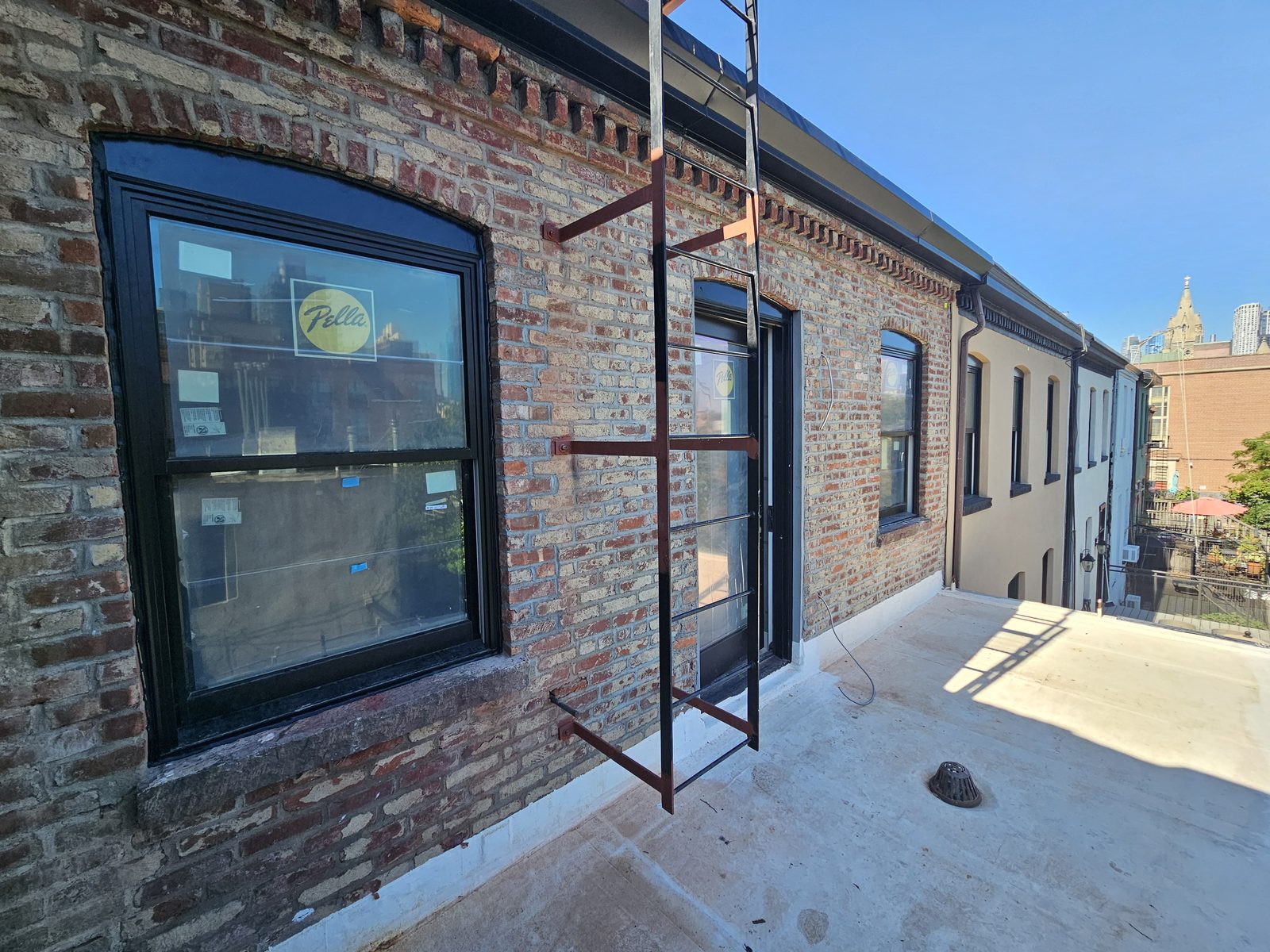 Roof terrace at 343 Hoyt Street with black Pella window and terrace door under the brick cornice