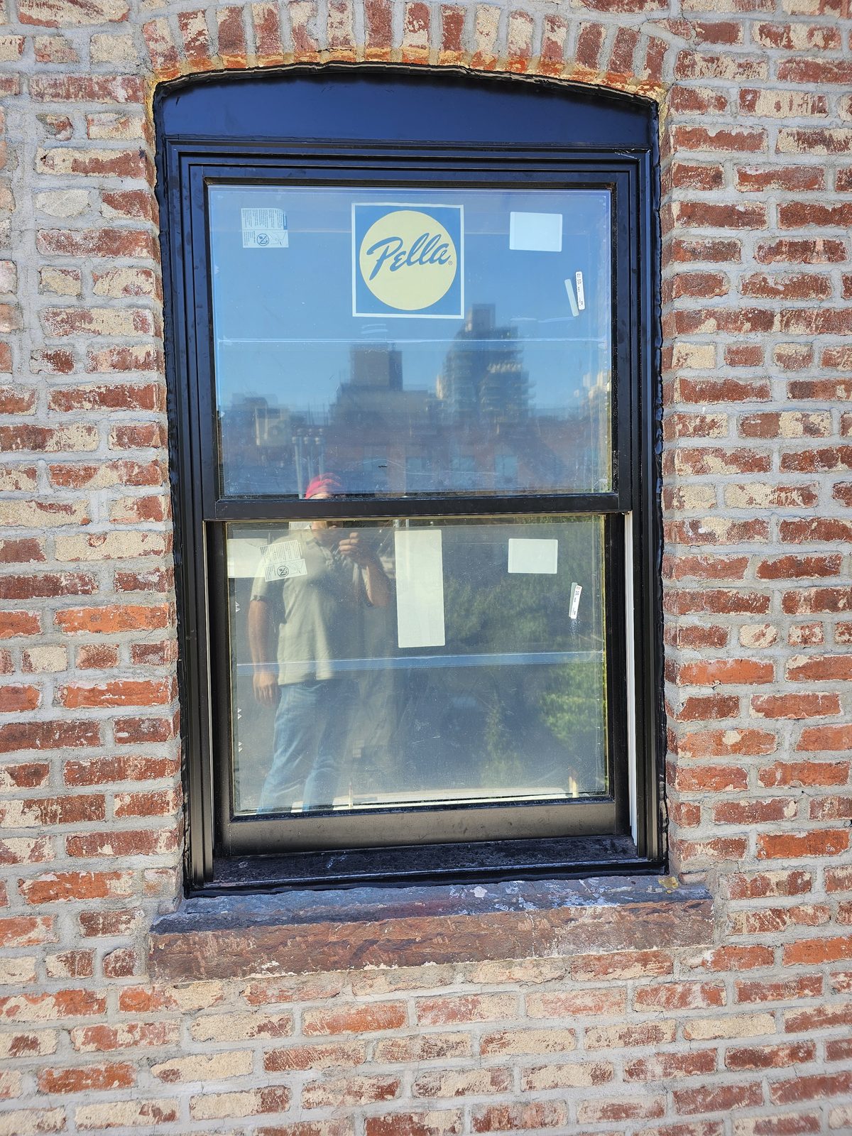 Close view of a black Pella double-hung window in a brick facade at 343 Hoyt Street