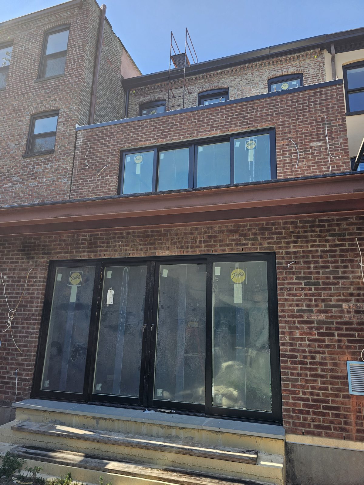 Full rear facade of 343 Hoyt Street showing Pella sliding doors, terrace door and windows on all floors