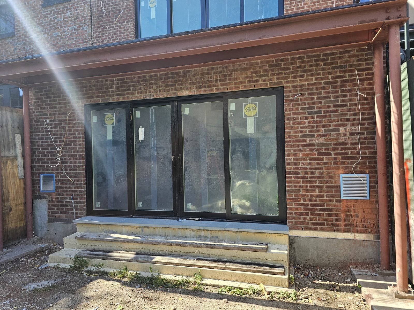 Four-panel Pella sliding door at the garden level of 343 Hoyt Street under a steel canopy