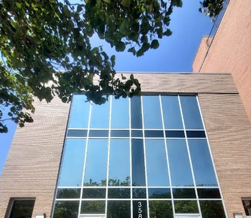 Glazed curtain wall front of the brick building at 3586 Nostrand Avenue, Brooklyn, seen from below