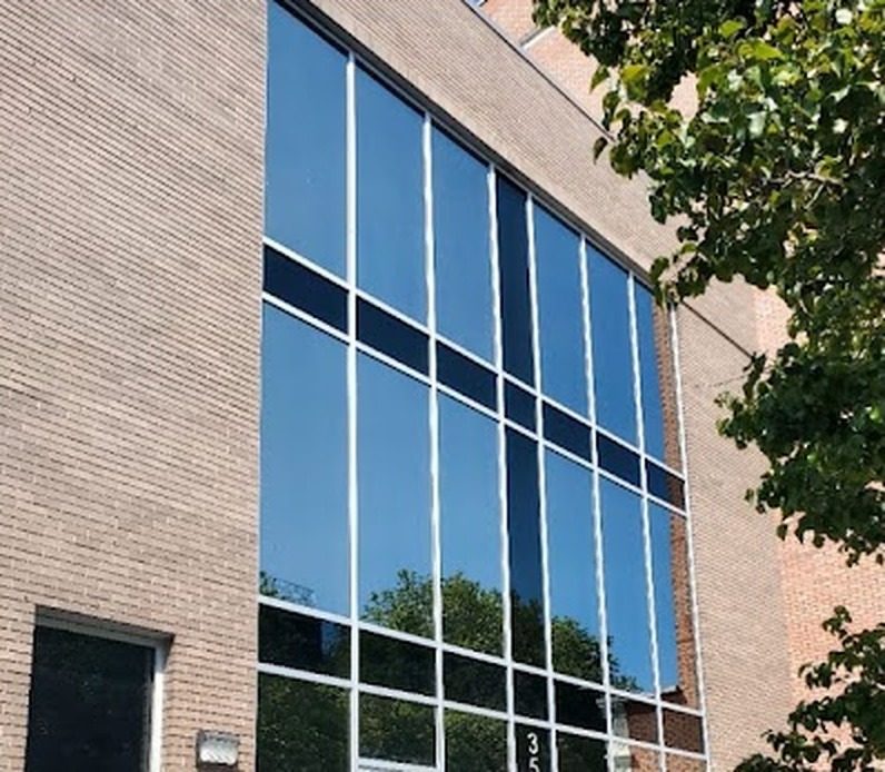 Curtain wall grid with solar-control glass on the brick building at 3586 Nostrand Avenue, Brooklyn