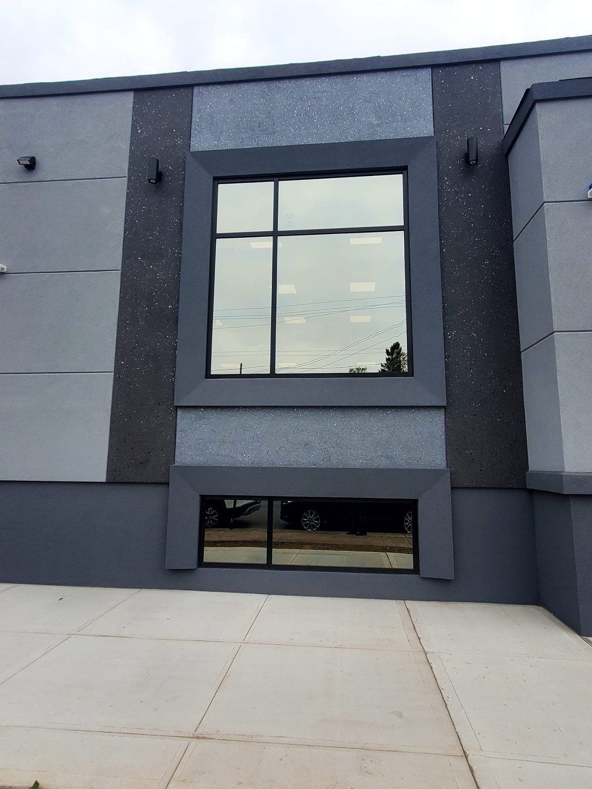 Large square fixed window with cross mullion and a basement ribbon window below at 3915 Flatlands Avenue