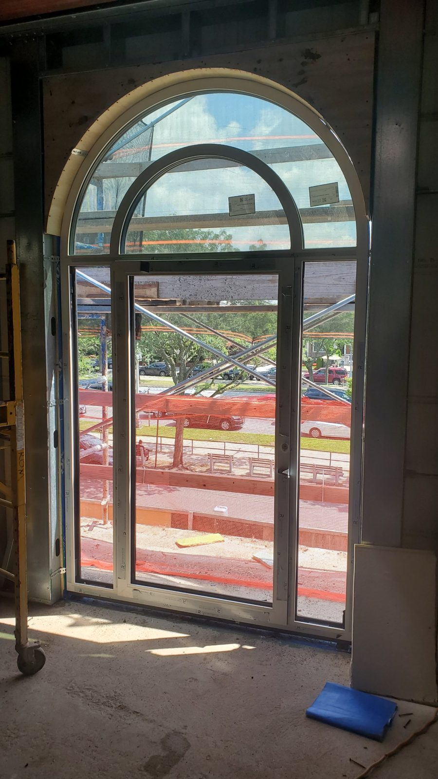 Arch-shaped aluminum curtain wall unit with a full-height glass entrance door, side lights and concentric arched transom at 4 Jim Lynch Drive, Long Branch NJ