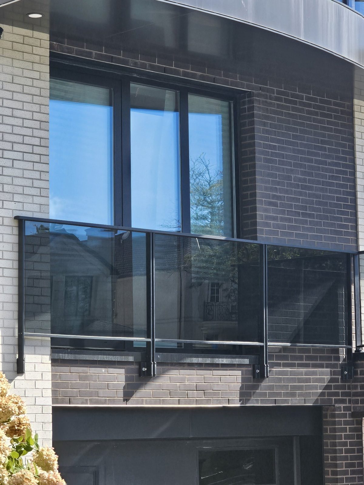Dark-framed Reynaers door with energy-efficient glass behind a balcony at 4107 Ocean Avenue, Brooklyn