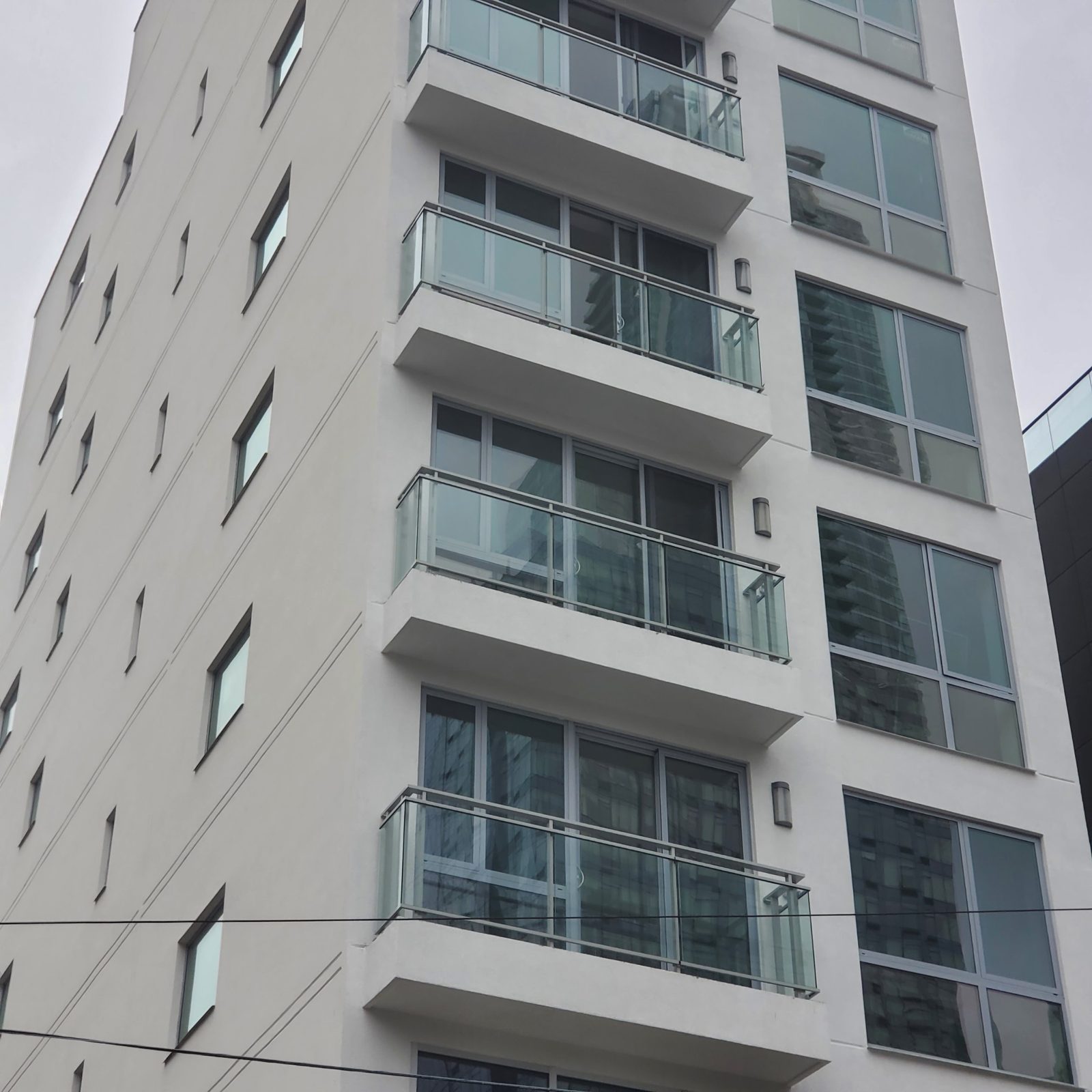 Custom aluminum and glass balcony railings by Aluminco on a new multi-story residential building at 42-44 Crescent