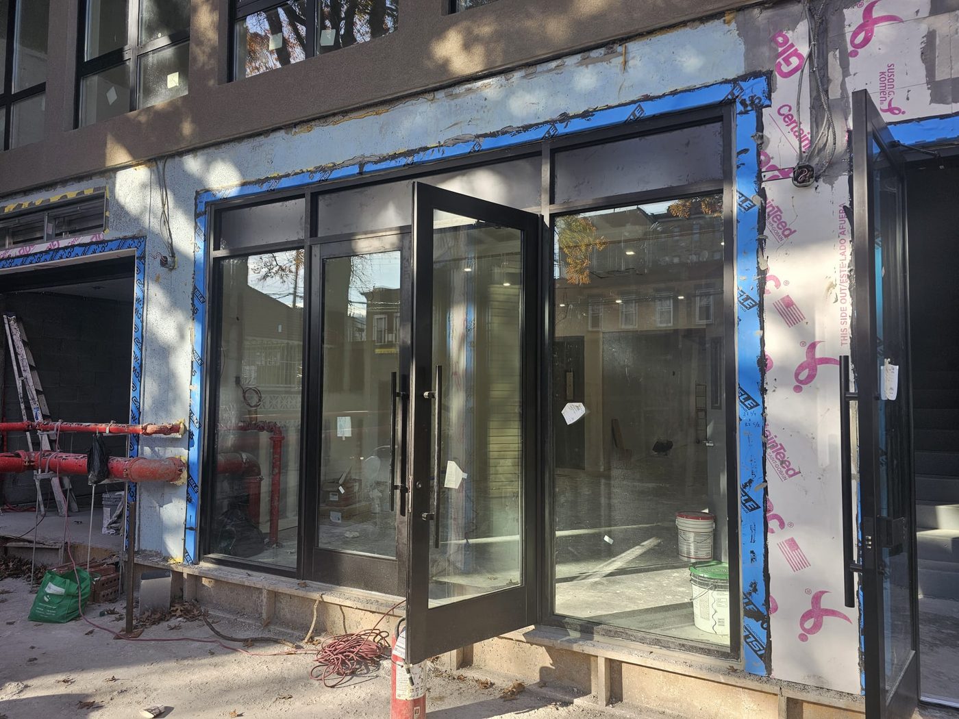 Ground-floor commercial storefront detail with Alutech aluminum framing and glass doors