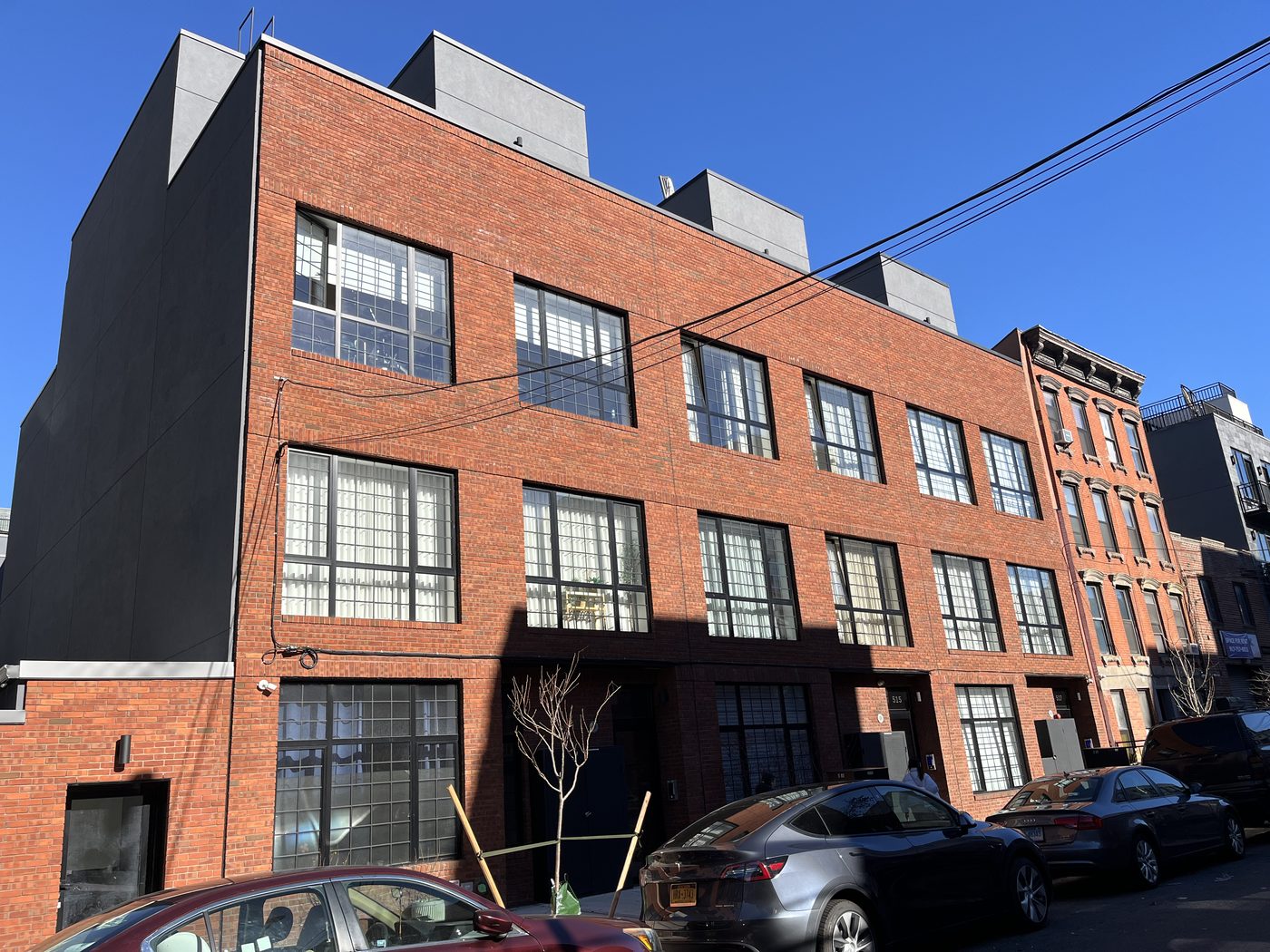 Neighbouring buildings of the same development on 47th Road, Long Island City, with matching grid aluminum windows, one tilt-and-turn sash open