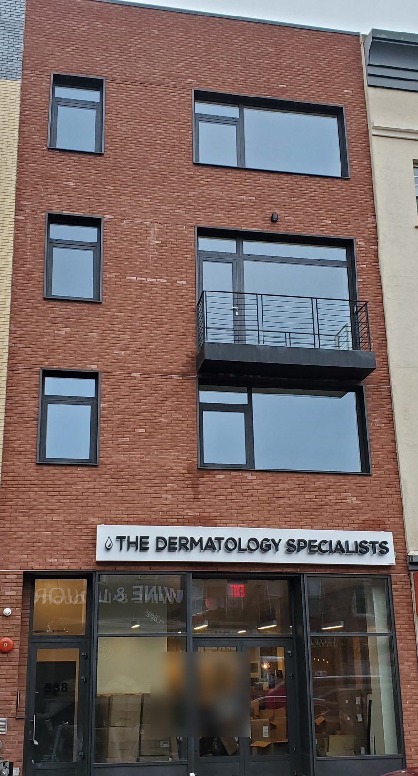 New brick building at 538 5th Avenue, Brooklyn, with dark Reynaers aluminum windows and balcony door above a commercial storefront